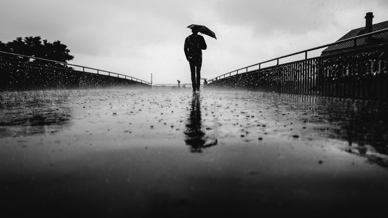 man-back-umbrella-raining-cloudy-urban-scene